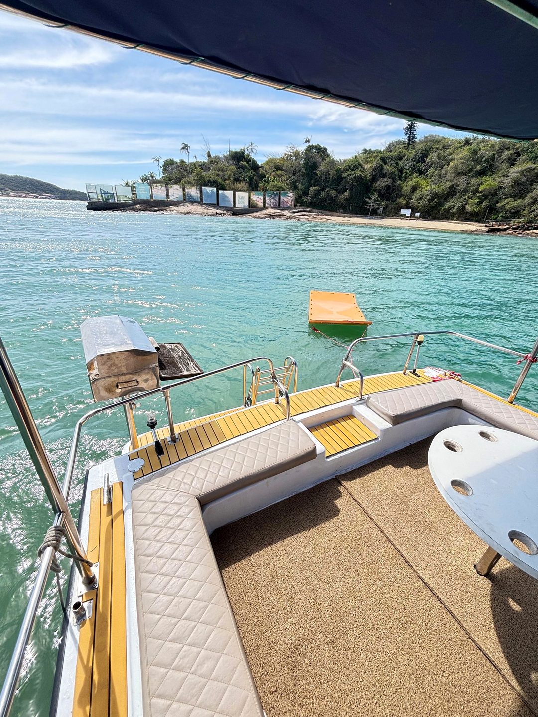 Convés da lancha da NauticTour com churrasqueira, estofados e tapete flutuante na água